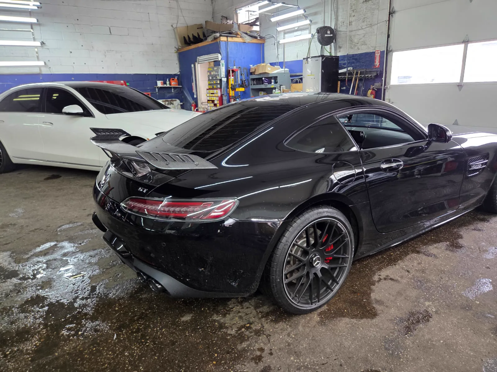 Black Mercedes-AMG GT parked inside the lit shop