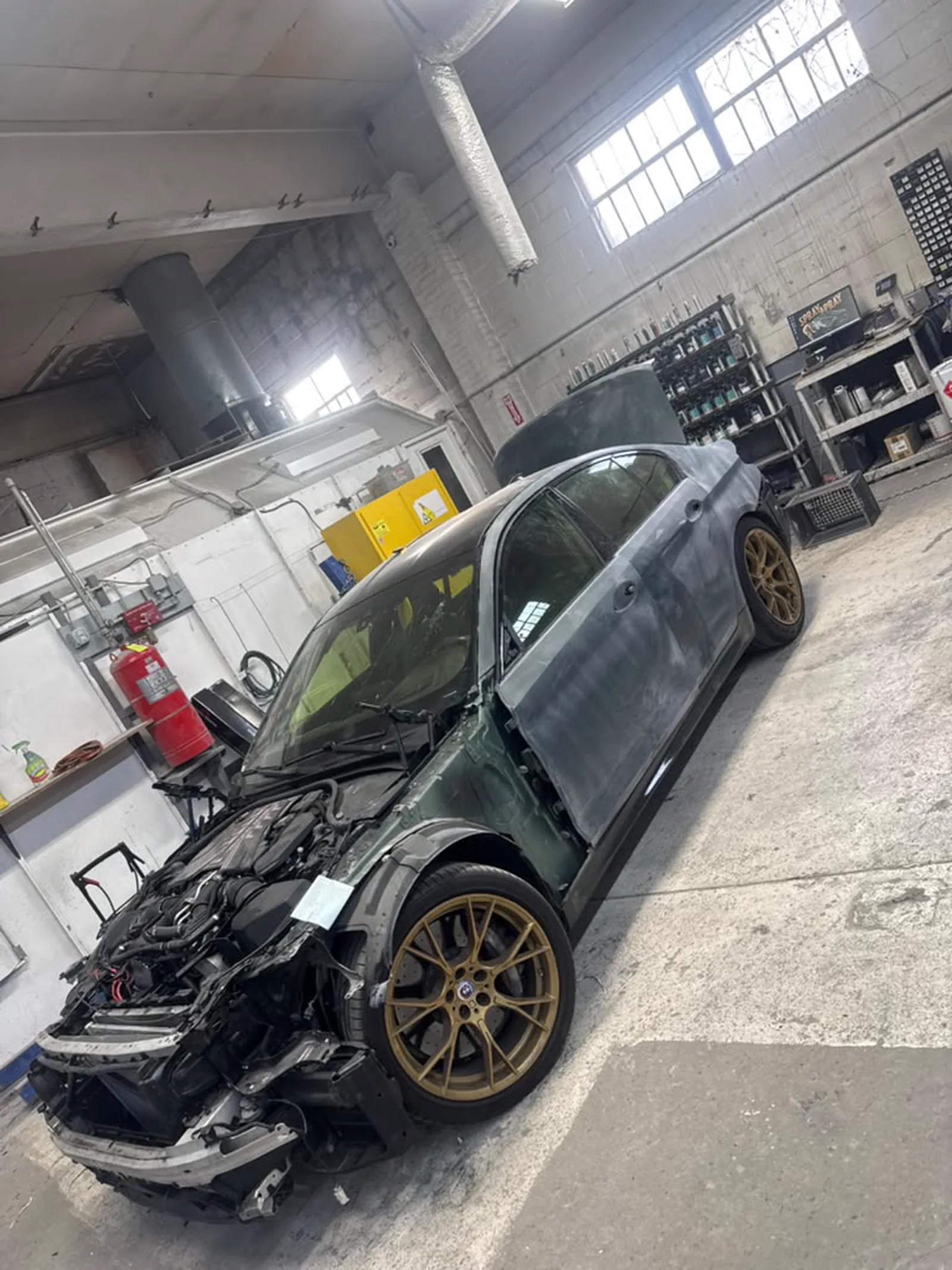 Black sedan with the front end crushed and the bumper torn away