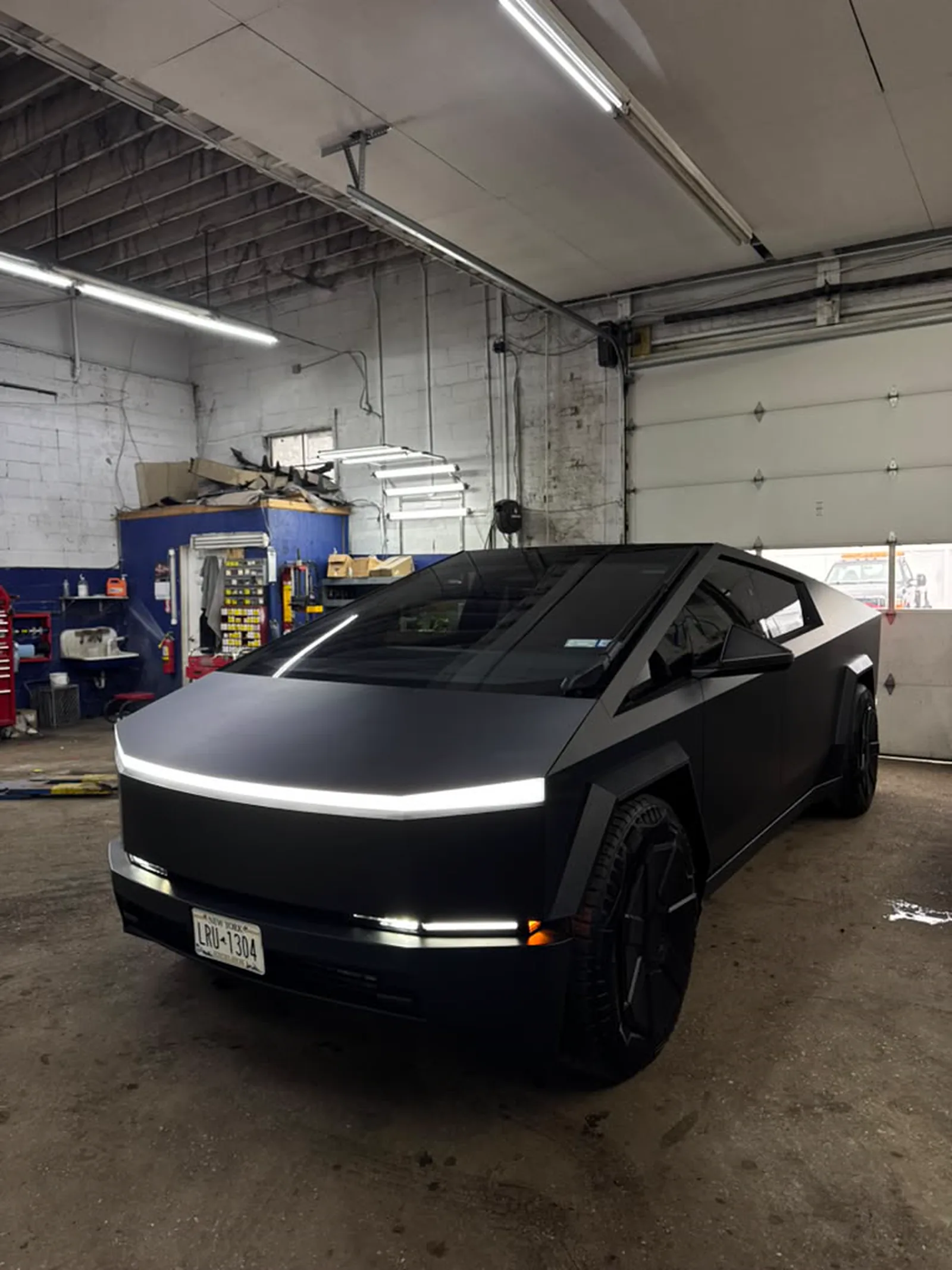 Tesla Cybertruck in a matte black wrap inside the shop