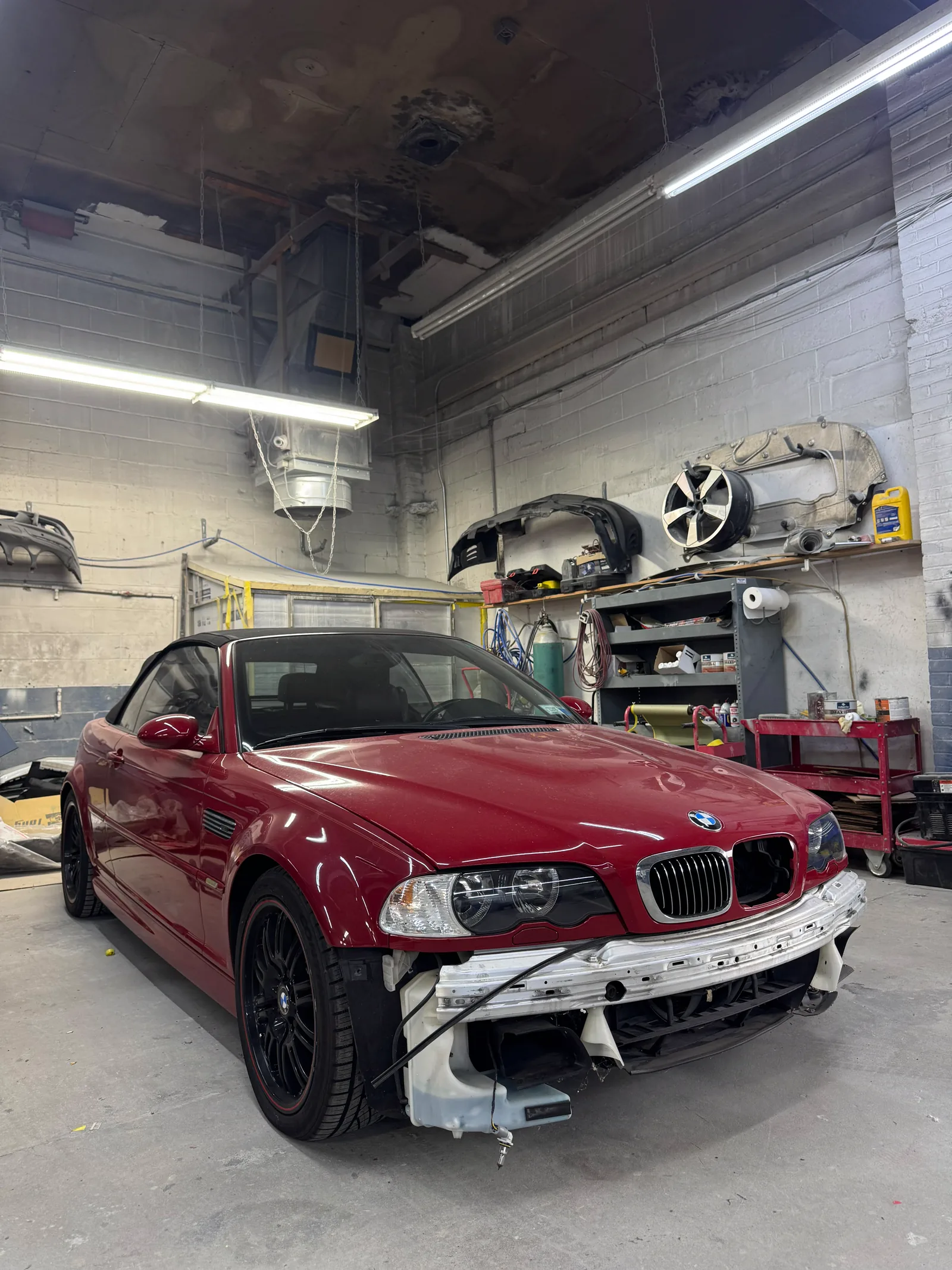 Imola red BMW M3 with the front bumper removed