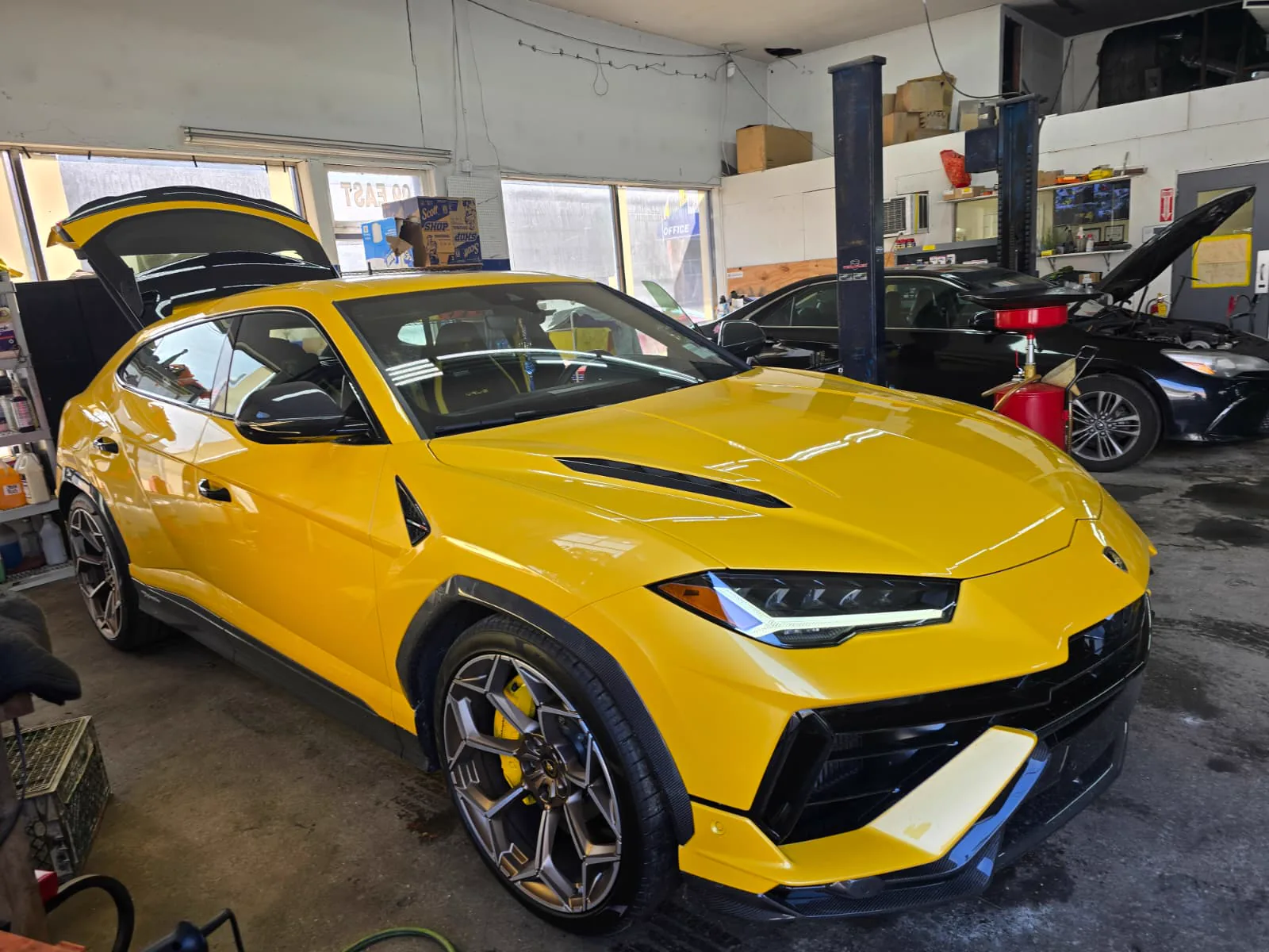 Lamborghini Urus wrapped in gloss yellow on the shop floor